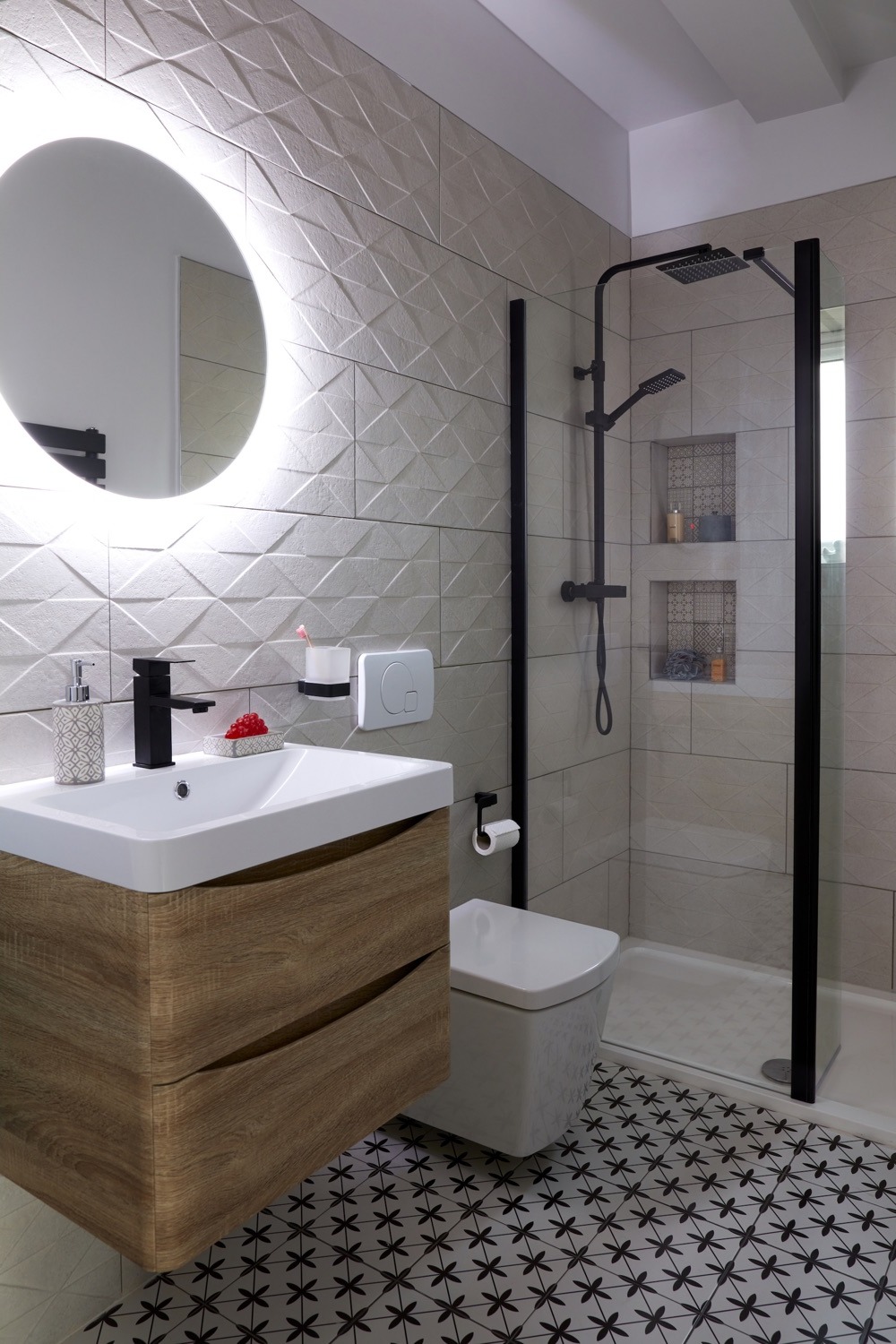 Shower room with backlit round mirror, textured white tiles, oak vanity and walk-in shower