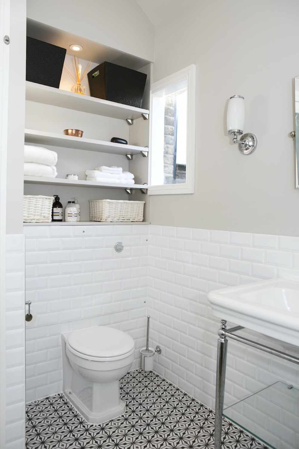 Recessed shelving above a close-coupled toilet with metro tiles