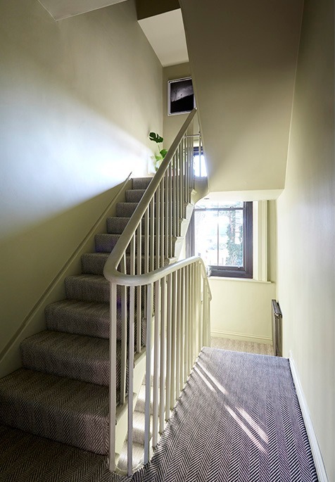 Staircase with white balustrade rising to the loft conversion