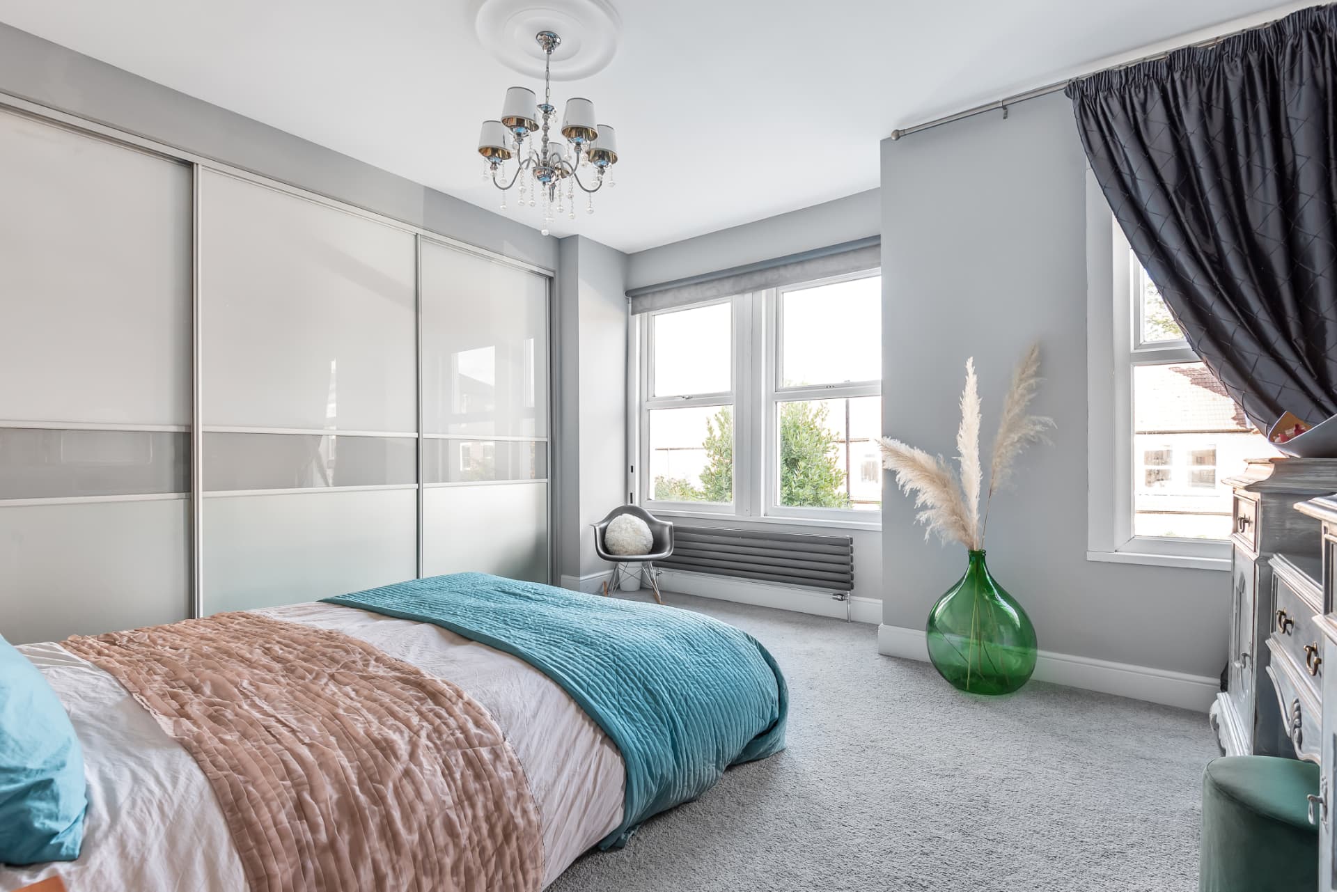 Main bedroom with sliding wardrobes, pampas grass and floor-to-ceiling curtains