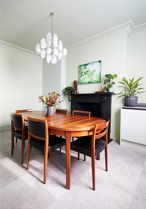 Dining area with round teak table, vintage pendant and potted plants