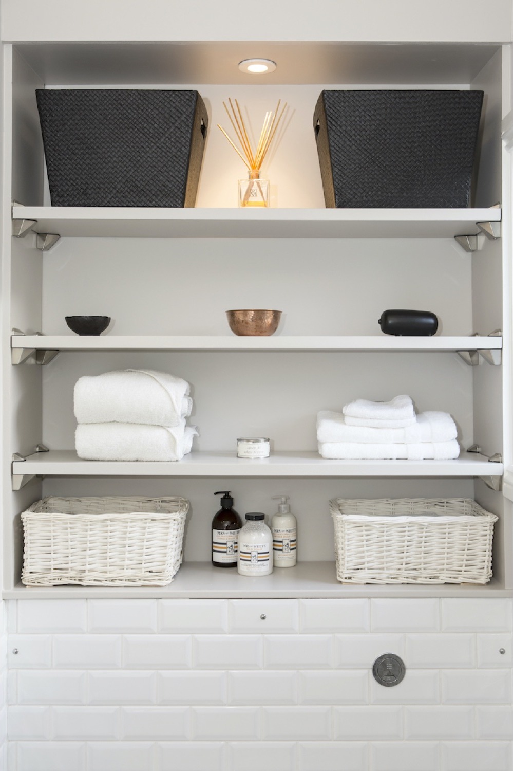 Recessed shelves with storage baskets and folded towels