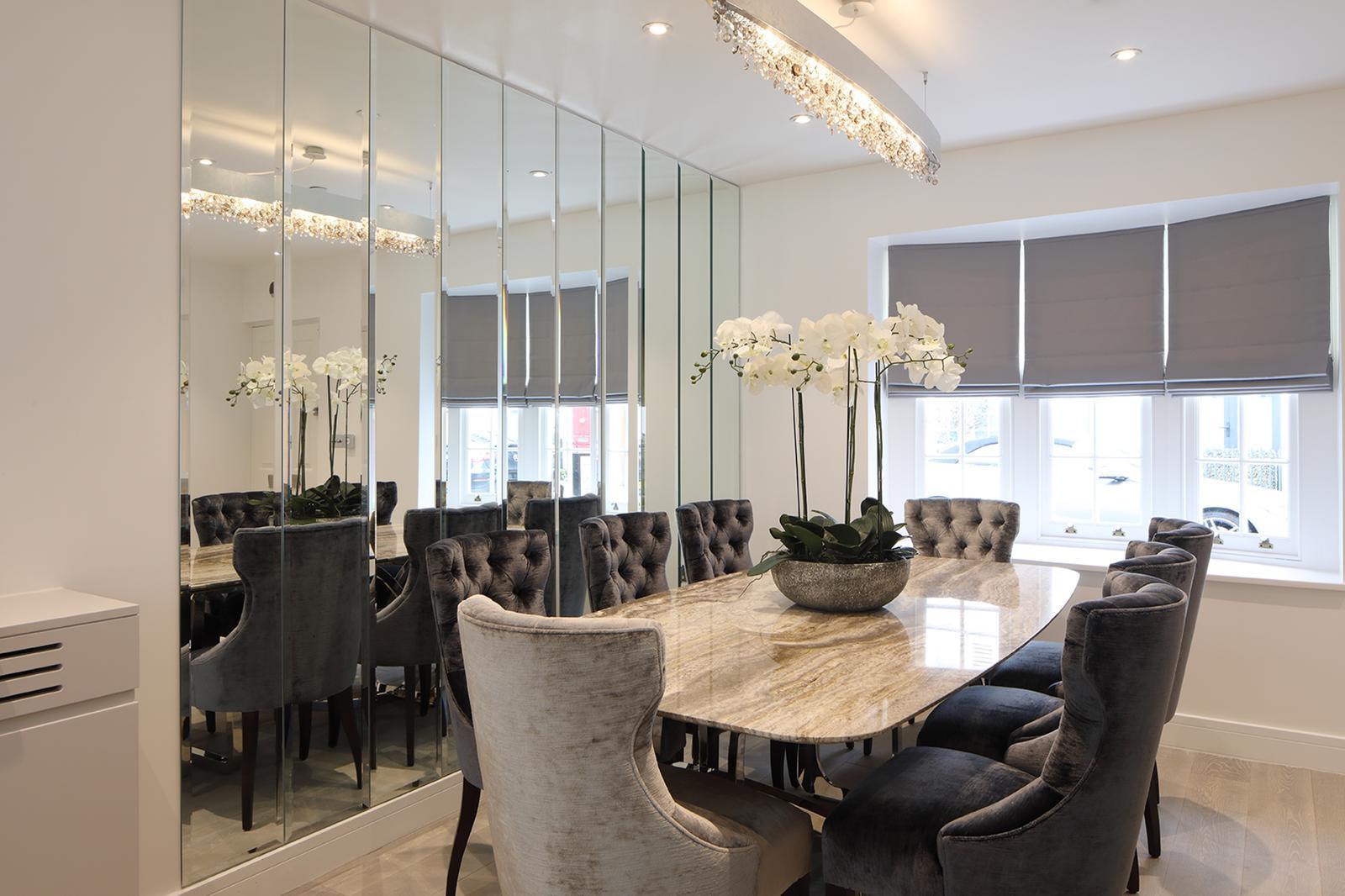 Dining room with velvet button-back chairs, marble table and floor-to-ceiling mirrored wardrobes