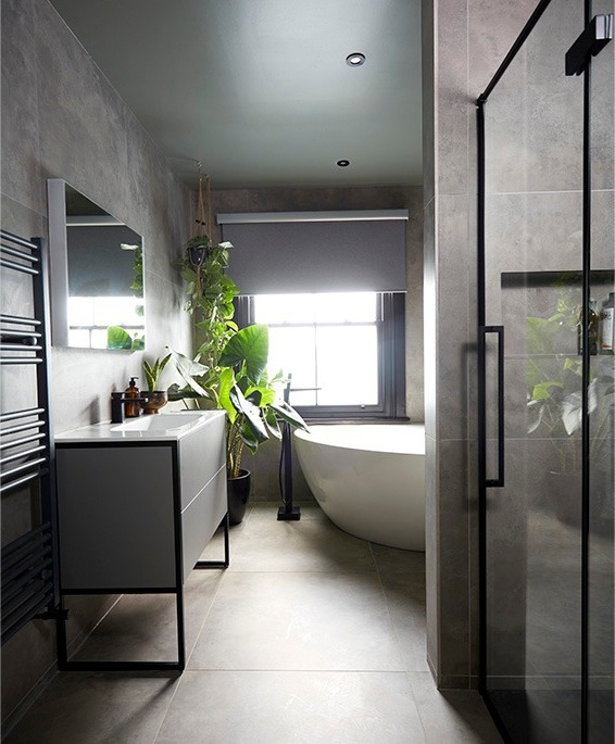 Bathroom with walk-in shower, black-framed vanity and freestanding bath beyond