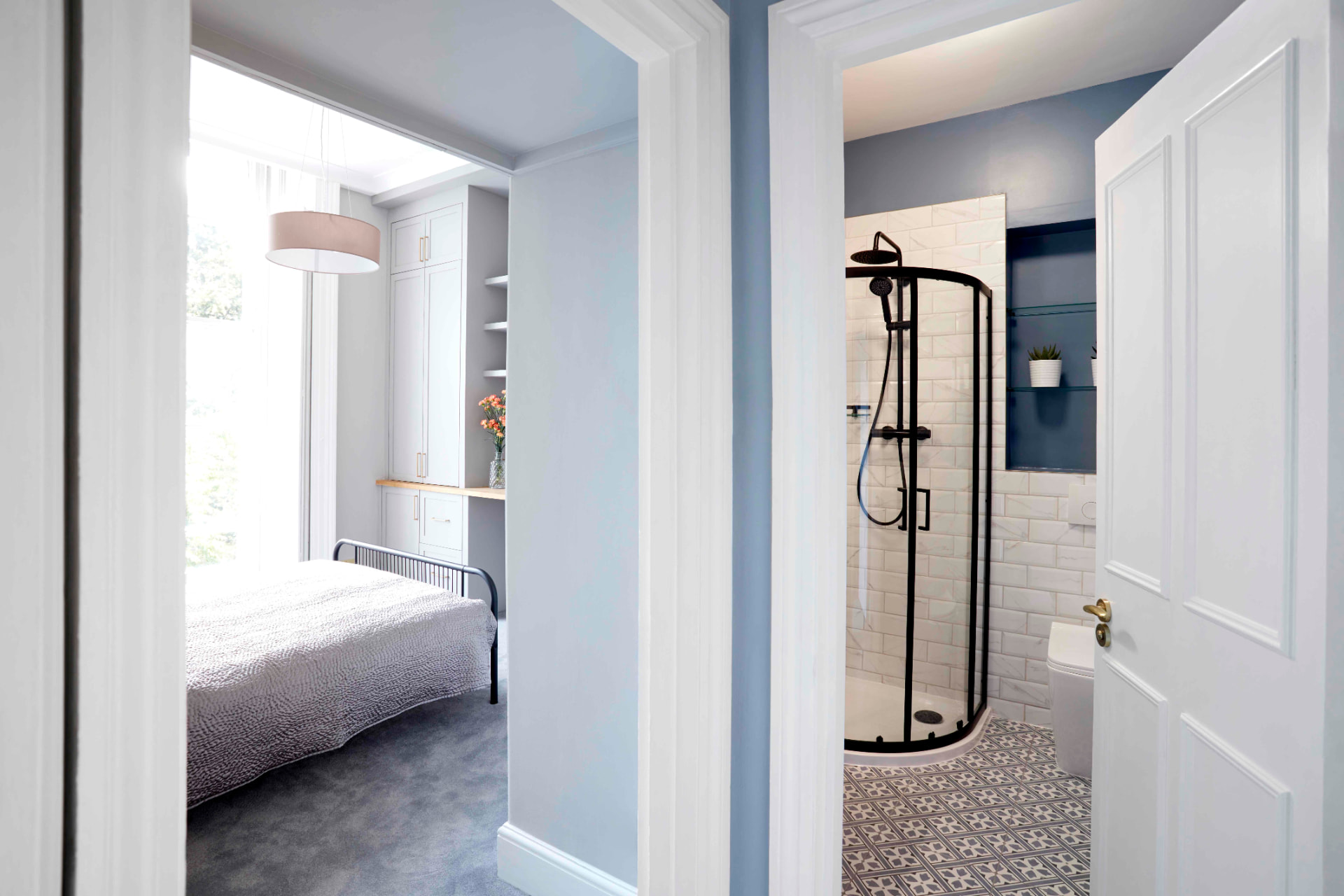 View from the bedroom through to the shower room with black-framed quadrant shower
